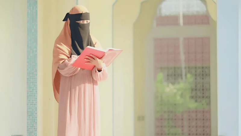 A female tutor providing Quran lessons for sisters in a private online class.